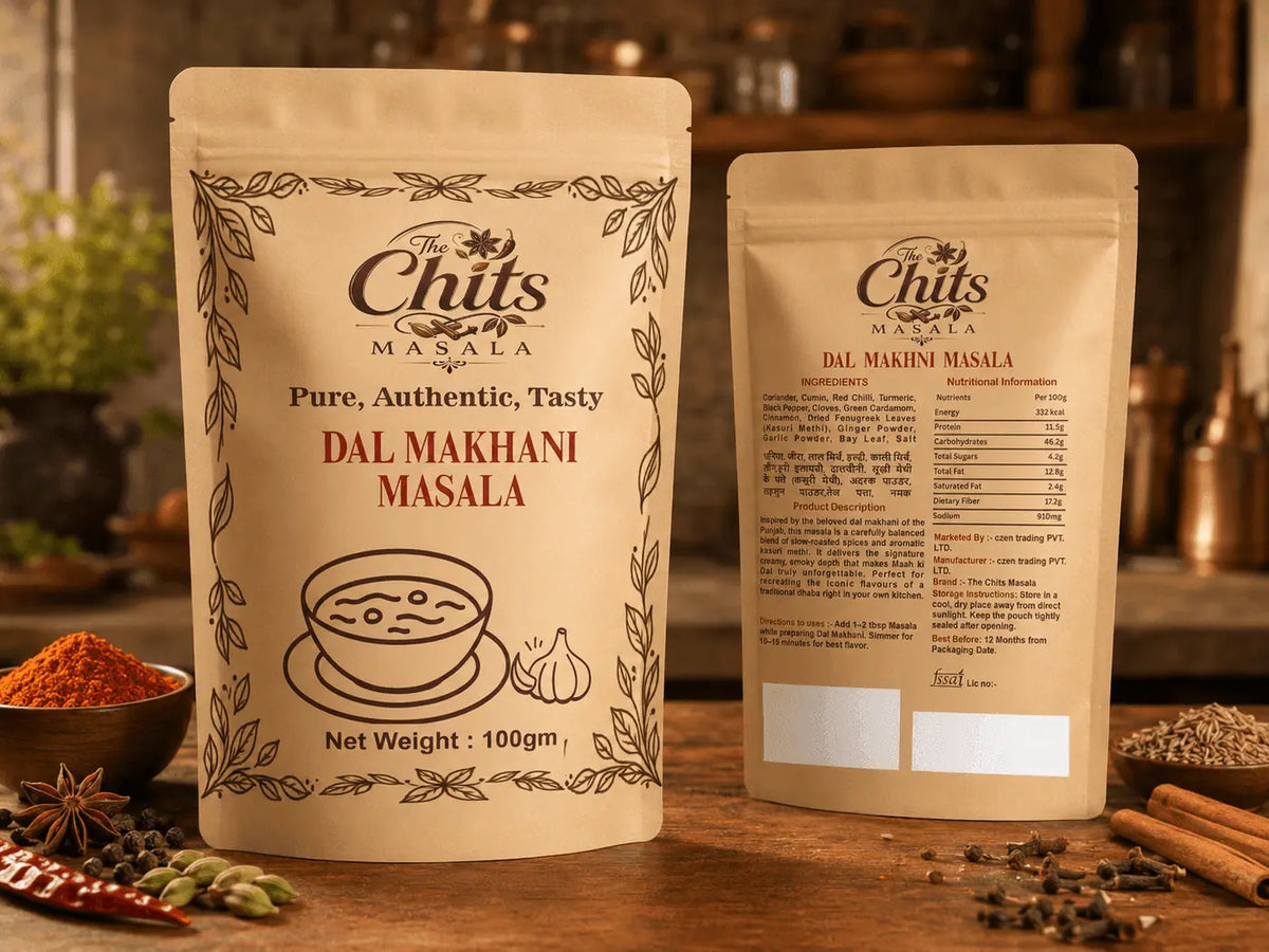 Two stand-up pouches of The Chits Masala Dal Makhani Masala shown on a wooden table with spices and kitchen decor in the background. One pouch shows the front label and the other shows the back label.