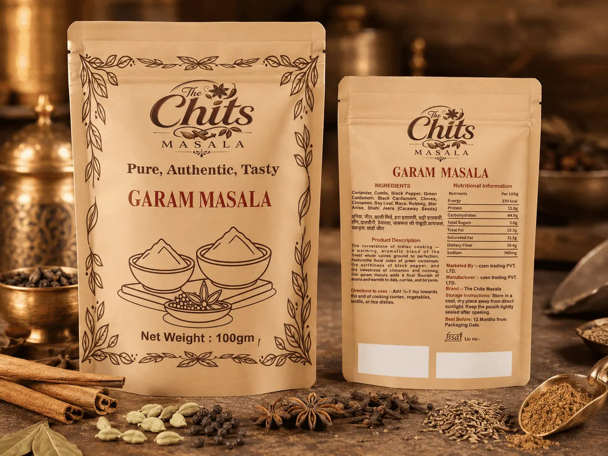 Two stand-up pouches of The Chits Masala Garam Masala spice mix displayed on a rustic wooden surface with cinnamon sticks, cardamom pods, and whole spices in the background.